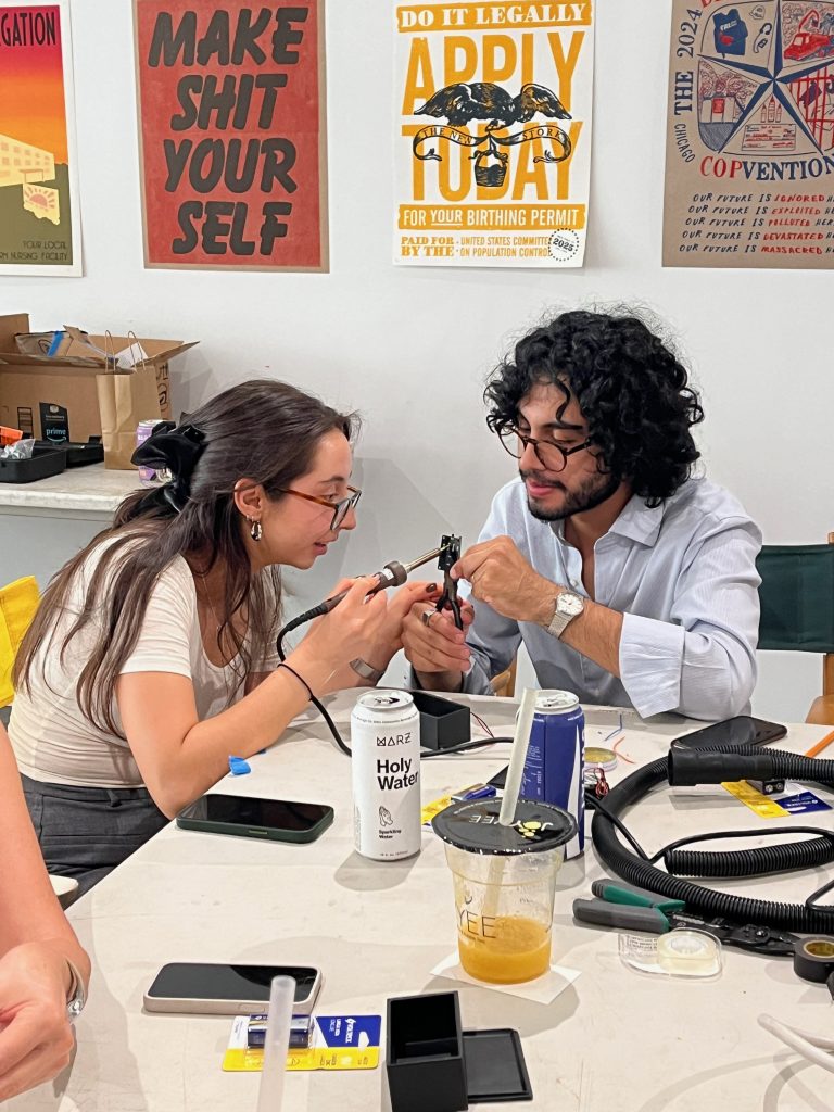 A photograph of two attendees of the VOZU workshop working together on their sound instruments. Courtesy of Co-Prosperity.