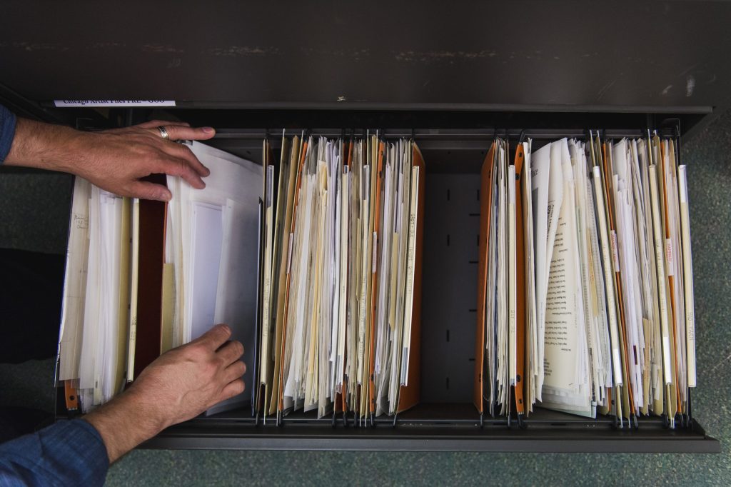 Image: Marc Fischer going through the Chicago Artists Files at the Harold Washington Library. Photo by Ryan Edmund Thiel.